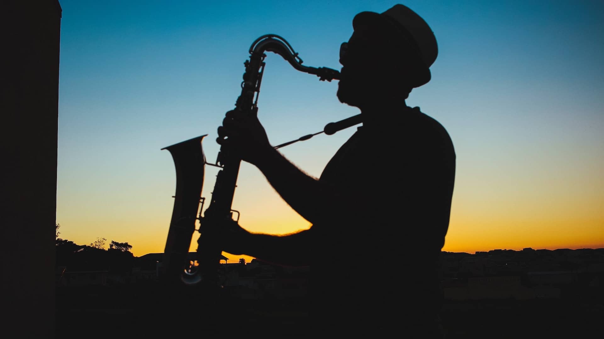 Gizonezko bat saxofoiarekin ilunabarrean 20230422