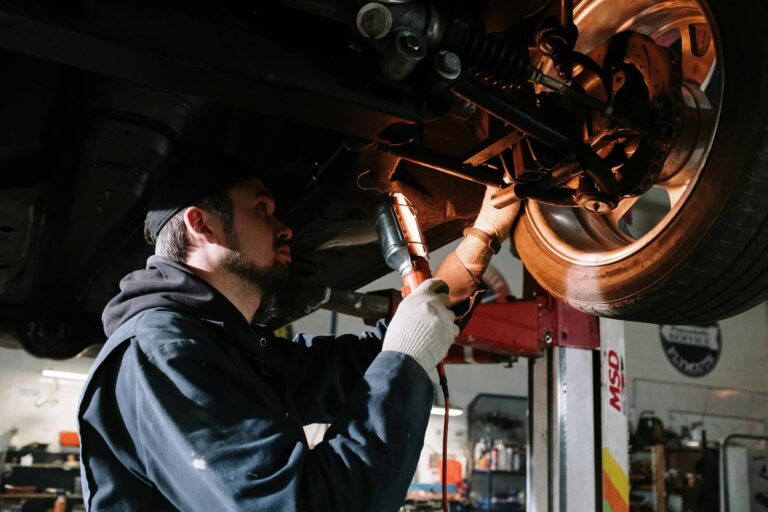 Gizonezko mekanikari bat auto baten gurpila konpontzen 20200517
