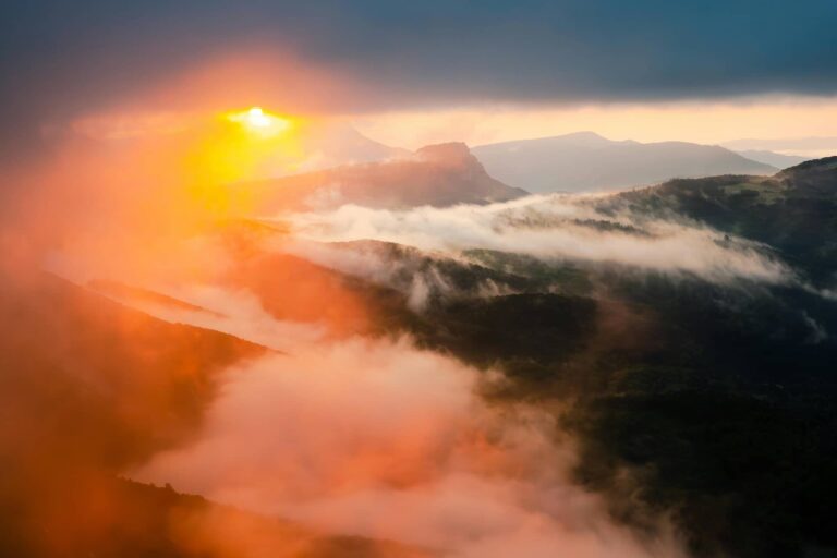 Eguzkia egunsentian eta lainoan mendien artean 20250929